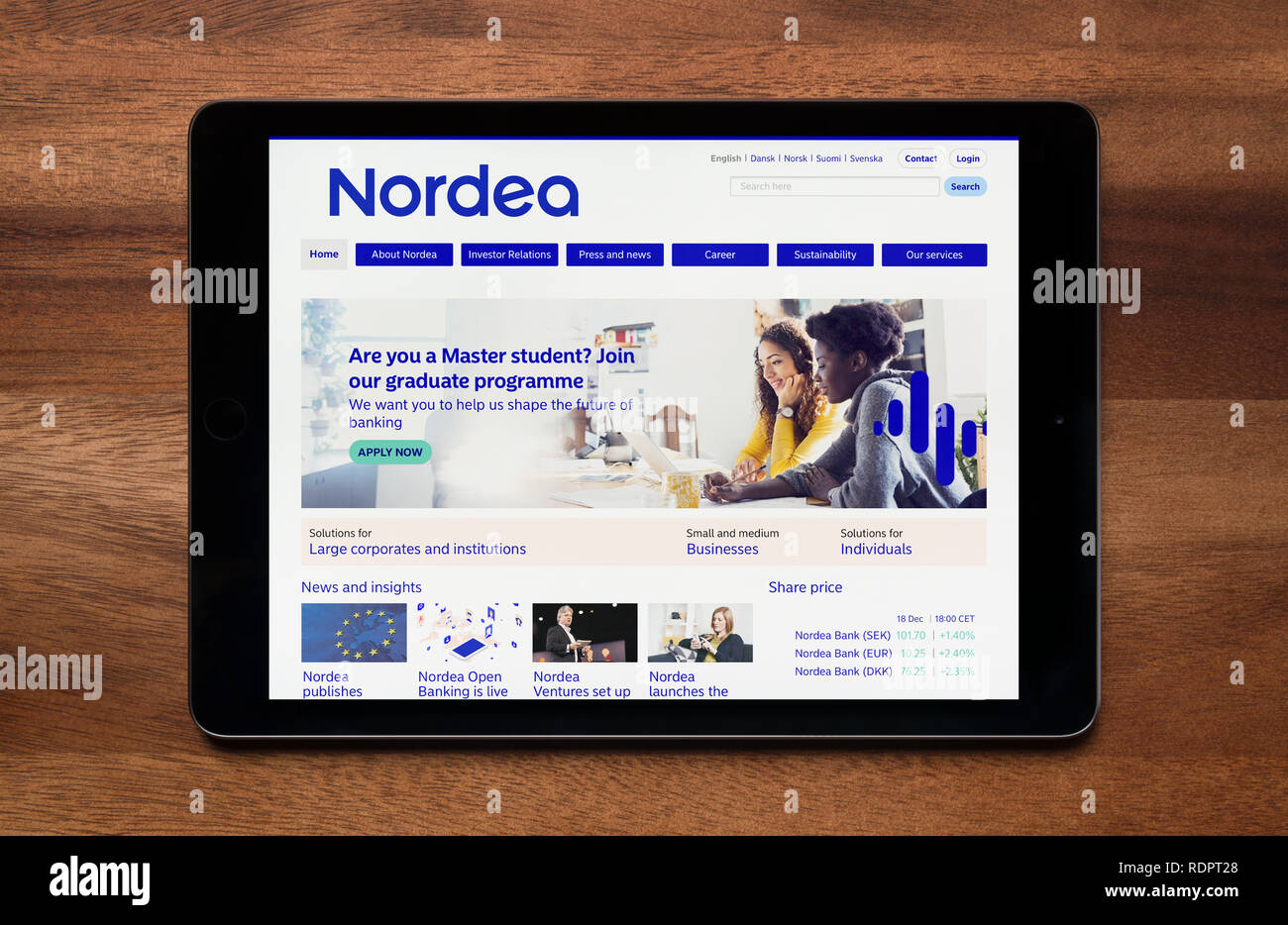 The website of Nordea Bank is seen on an iPad tablet, which is resting on a wooden table (Editorial use only). Stock Photo