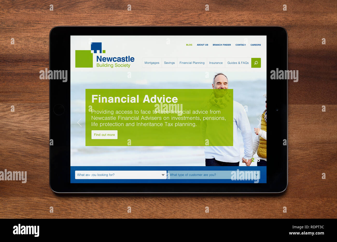 The website of Newcastle Building Society is seen on an iPad tablet, which is resting on a wooden table (Editorial use only). Stock Photo