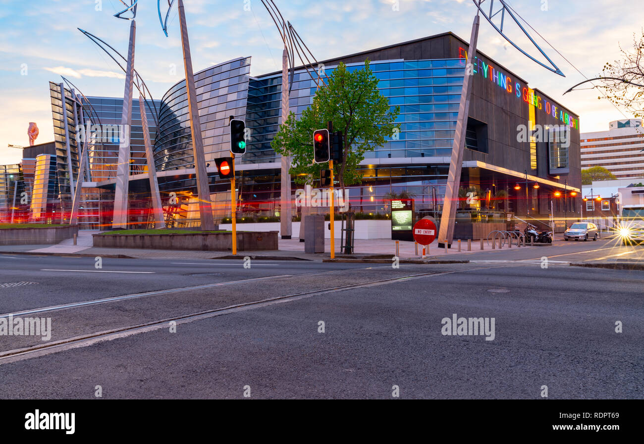 CHRISTCHURCH NEW ZEALAND - OCTOBER 10 2018; building example modern architecture glass and  steel curving wavy facade in evening light and light trail Stock Photo