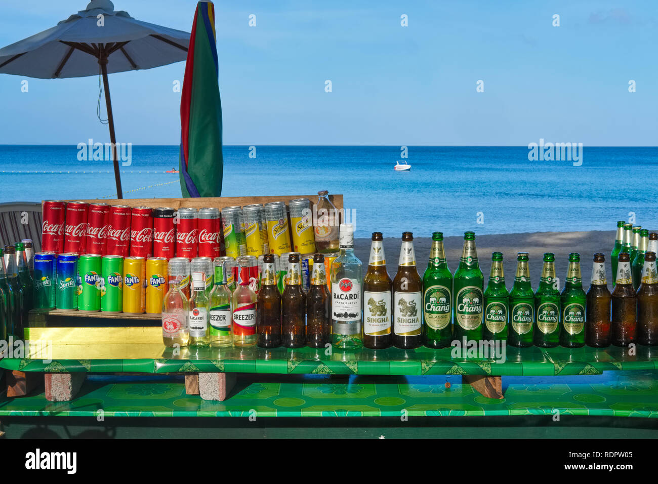 Cans of Coca Cola, other soft drinks & beer bottles at a beachside stall, on an early morning at Bang Tao (Bangtao) Beach, Bang Tao, Phuket, Thailand Stock Photo