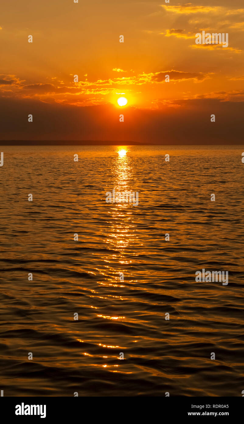 Golden Sunset into the sea with the silhouette of an island Stock Photo ...