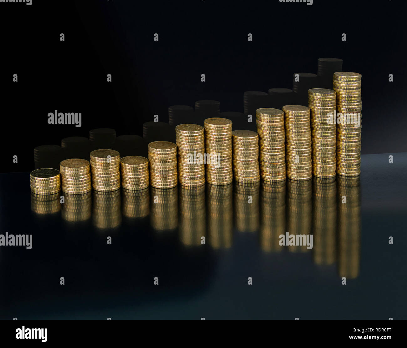 A chart of twelve stacks of gold coloured euro coins Stock Photo
