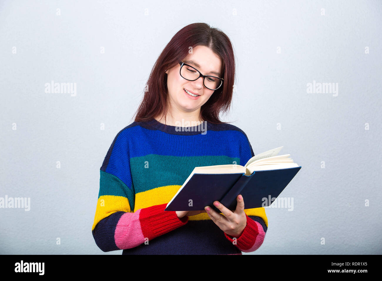 Happy student girl holding a open book reading pages and smile Stock ...