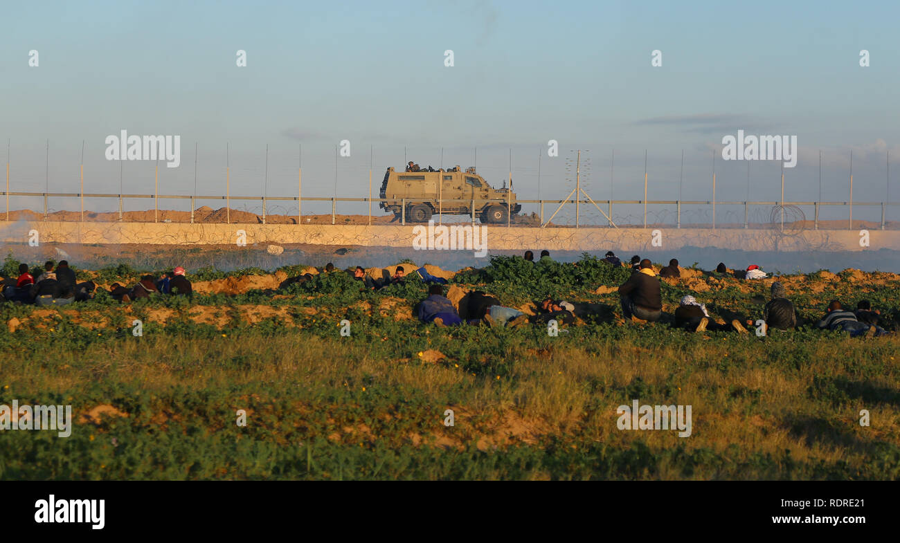 January 18, 2019 - Gaza, ???? ???????/????, Palestine - Palestinian demonstrators seen taking cover during clashes between Israeli forces and Palestinians while taking part in the large-scale march on the Gaza-Israel separation fence east of Khan Younis. Credit: Yousef Masoud/SOPA Images/ZUMA Wire/Alamy Live News Stock Photo