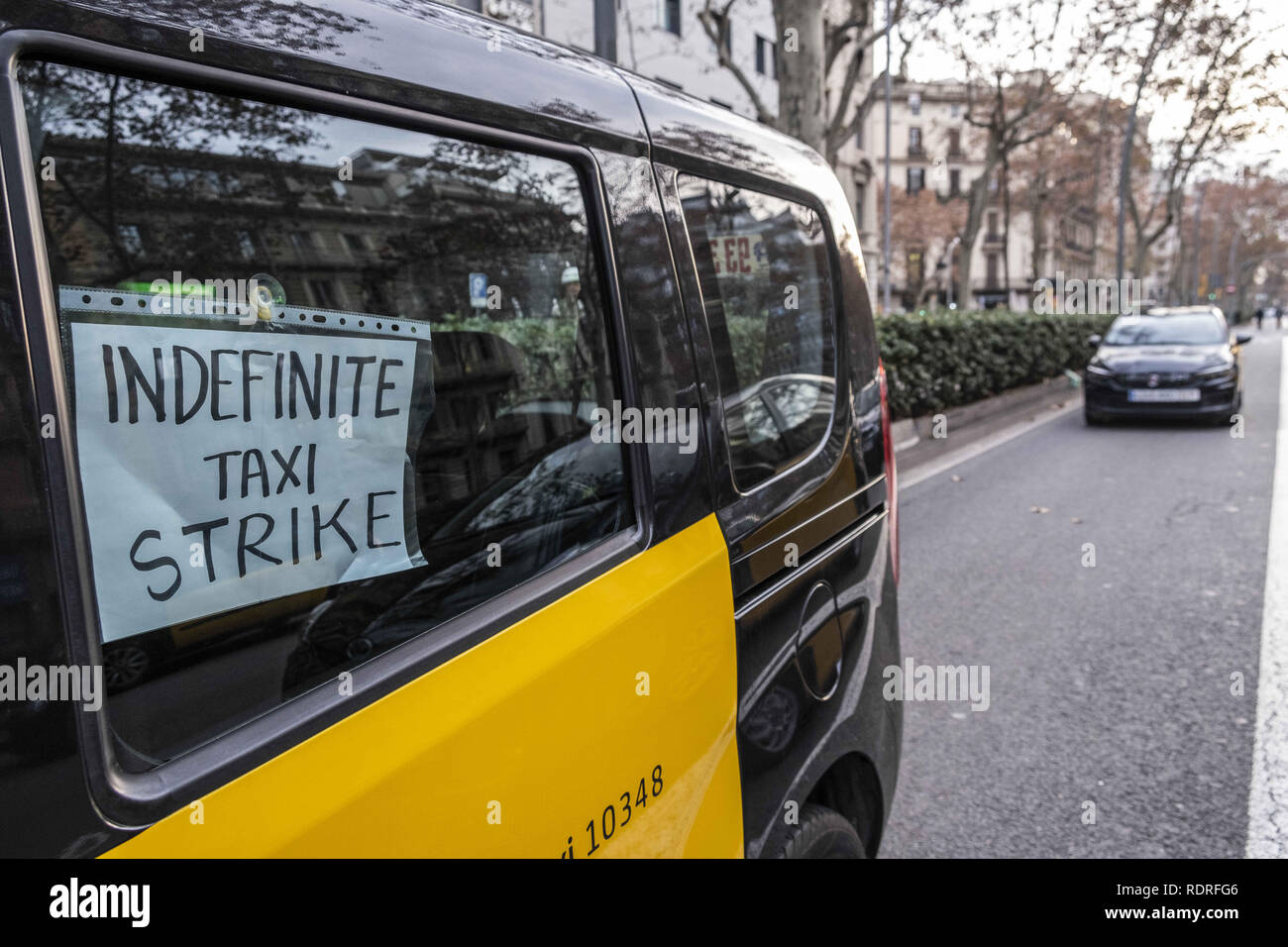 Barcelona, Catalonia, Spain. 18th Jan, 2019. A taxi is seen with a placard saying Indefinite Taxi Strike.After broken negotiations with the Government of Catalonia, the taxi drivers of Barcelona return to the indefinite strike by occupying the Gran VÃ-a of Barcelona. Taxi drivers have been touring the center of Barcelona in a demonstration where there have been attacks against Uber and Cabify drivers with a VTC license. Credit: Paco Freire/SOPA Images/ZUMA Wire/Alamy Live News Stock Photo