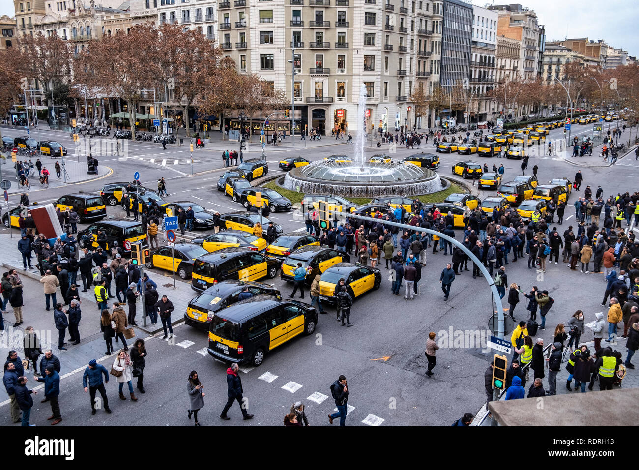 A group of taxis and their drivers are seen parked in the center of the city during the protest. After broken negotiations with the Government of Catalonia, the taxi drivers of Barcelona return to the indefinite strike by occupying the Gran Vía of Barcelona. Taxi drivers have been touring the center of Barcelona in a demonstration where there have been attacks against Uber and Cabify drivers with a VTC license. Stock Photo