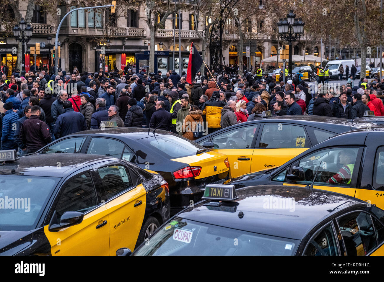 Taxis seen parked with a large group of taxi drivers during the protest. After broken negotiations with the Government of Catalonia, the taxi drivers of Barcelona return to the indefinite strike by occupying the Gran Vía of Barcelona. Taxi drivers have been touring the center of Barcelona in a demonstration where there have been attacks against Uber and Cabify drivers with a VTC license. Stock Photo