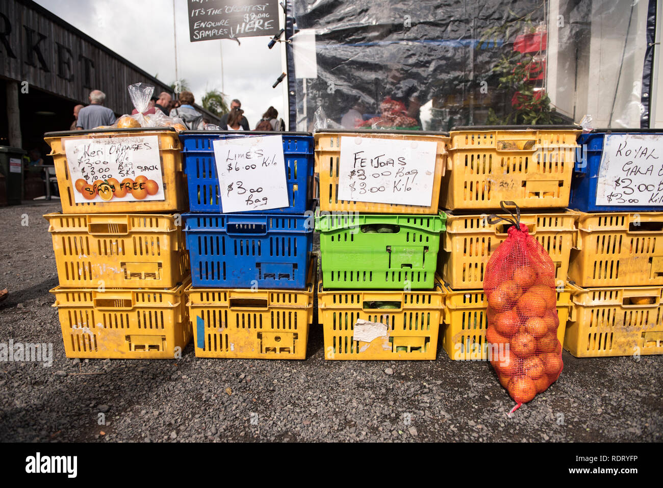 Colorful plastic baskets filled with fresh produce on display at the Old Packhouse Market in Kerikeri, New Zealand. Stock Photo