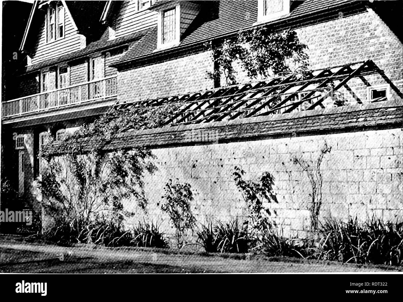. Gardens for small country houses . Gardens, English. FIG. 145.—CONCRliTE WALLS AT LAMBAY.. FIG. 146, —WALL MASKING KITCHEN QUARTERS. 1789 is on a stone of the wall, his authorship must be doubted. The writer of this has seen a serpentine wall at a Suffolk house of late in the eighteenth century. A good modern example, a single brick thick, designed by Mr. F. W. Troup, is illustrated in Small Country Houses of To-day. Built with the same purpose as a serpentine wall, i.e., to give somewhat sheltered bays for fruit, is the straight wall with square breaks at a Buck- inghamshire house designed  Stock Photo