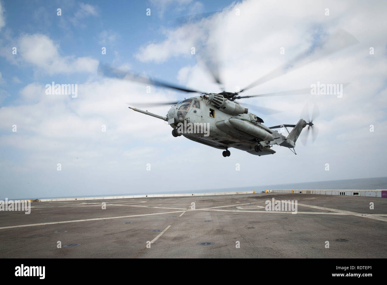 A U.S. Marine Corps CH-53E Super Stallion with Marine Medium Tiltrotor Squadron 166 Reinforced, 13th Marine Expeditionary Unit (MEU), prepares to land aboard the San Antonio-class amphibious transport dock USS Anchorage (LPD 23), Jan. 16, 2019. The Essex Amphibious Ready Group and the 13th MEU are deployed to the U.S. 5th fleet area of operations in support of naval operations to ensure maritime stability and security in the Central Region, connecting the Mediterranean and the Pacific through the western Indian Ocean and three strategic choke points. (U.S. Marine Corps photo by Sgt. Victoria D Stock Photo