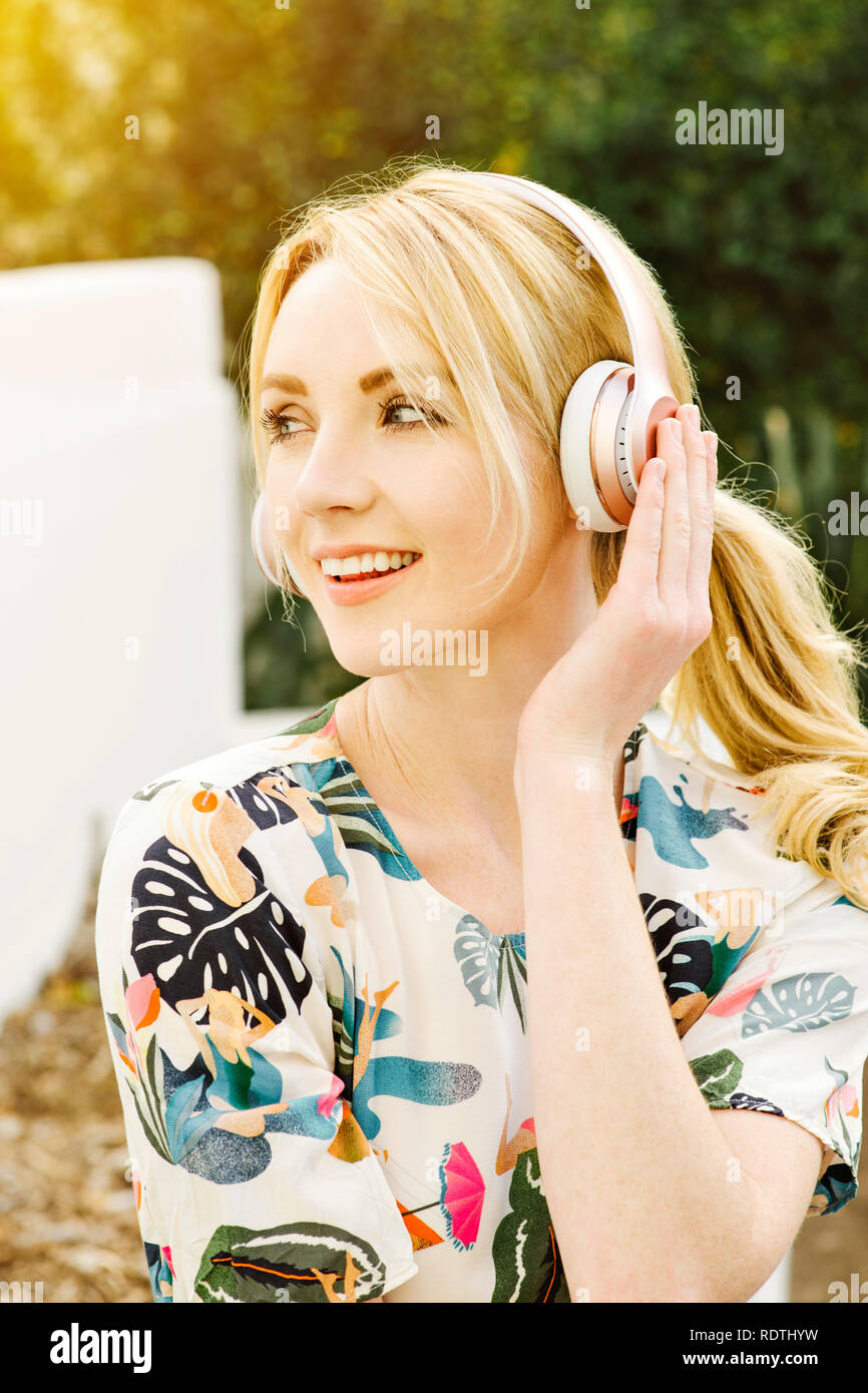 Millennial Female listens to music on her headphones and has a big smile happy and having fun Stock Photo