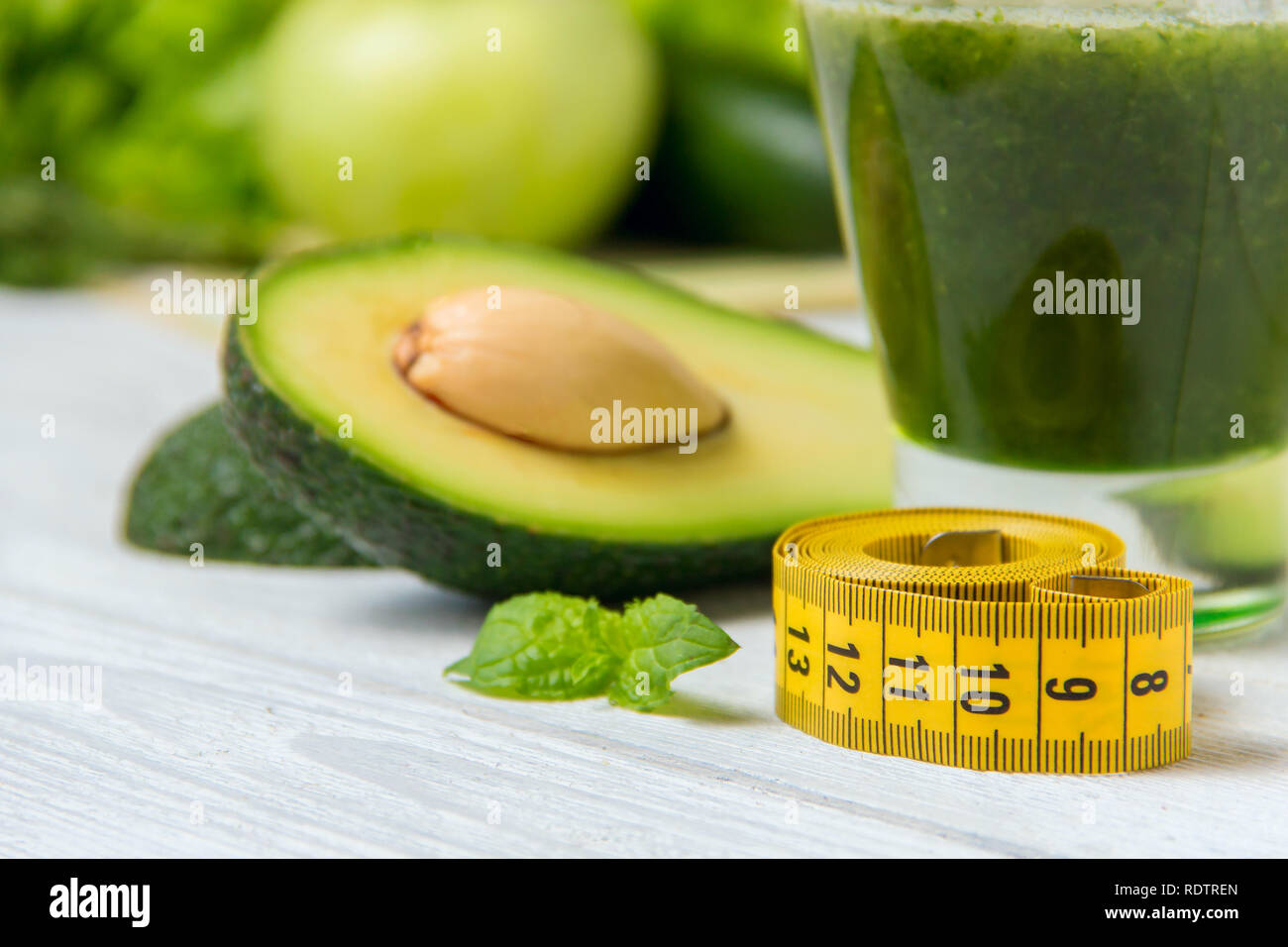 Healthy green smoothie with ingredients on white wooden background. Stock Photo