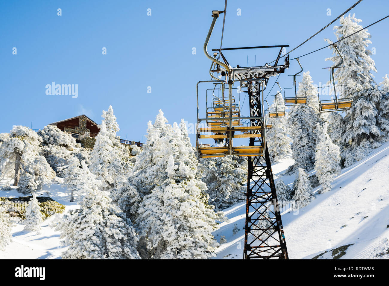 Mount Baldy (Mt San Antonio) ski lift on a sunny day; snow covering the ground and the pine trees, Los Angeles county, California Stock Photo