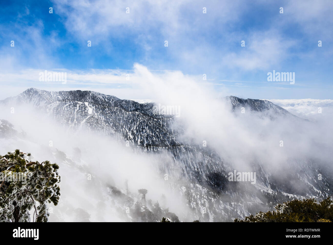 Changing weather with fog rising up from the valley, Mount San Antonio (Mt Baldy), south California Stock Photo