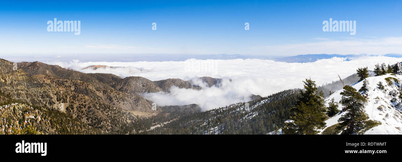 Sunny winter day with fallen snow and a sea of white clouds on the trail to Mt San Antonio (Mt Baldy), Los Angeles county, southern California Stock Photo
