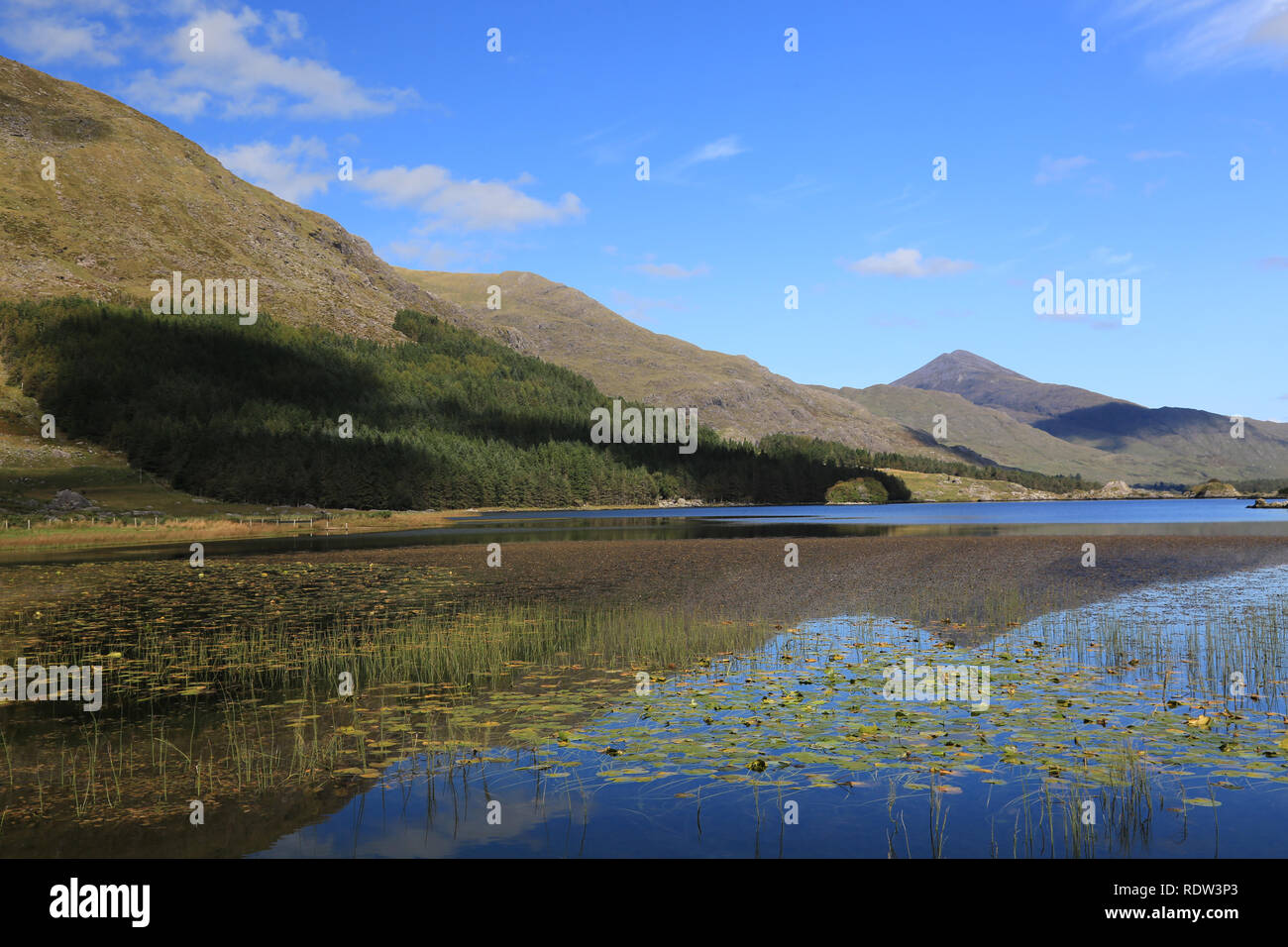 calm waters of lake hidden under the shadows of irelands highest mountain, black, valley, county kerry, irerland Stock Photo