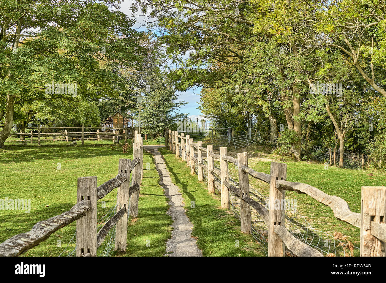 A rural footpath passing between two wooden fences. Stock Photo