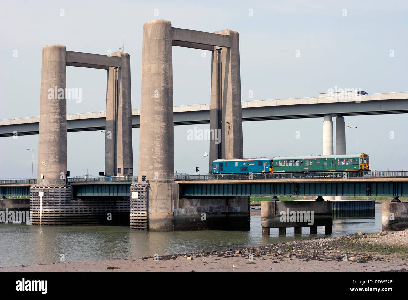 A class 73 electro diesel locomotive number 73136 'Perseverance' and observation saloon number 975025 'Caroline' crossing the King's Ferry Bridge. Stock Photo