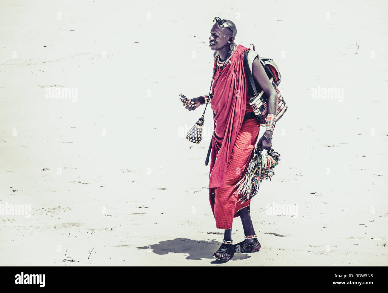 DIANI BEACH, KENYA - OCTOBER 14, 2018: Unindentified African man wearing traditional Masai clothes on Diani beach, Kenya Stock Photo