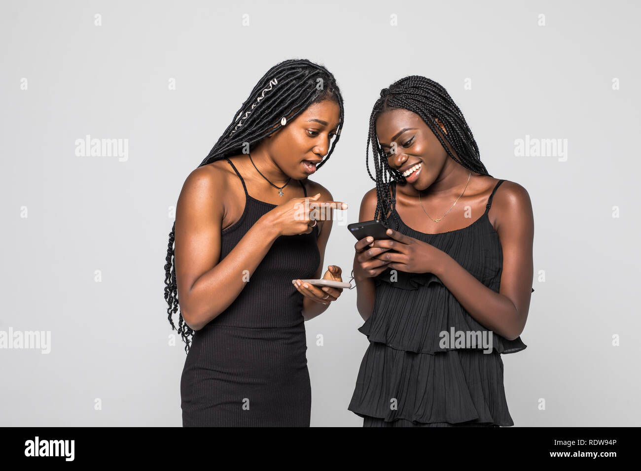 Two african women expressing excitement or surprise while both using ...