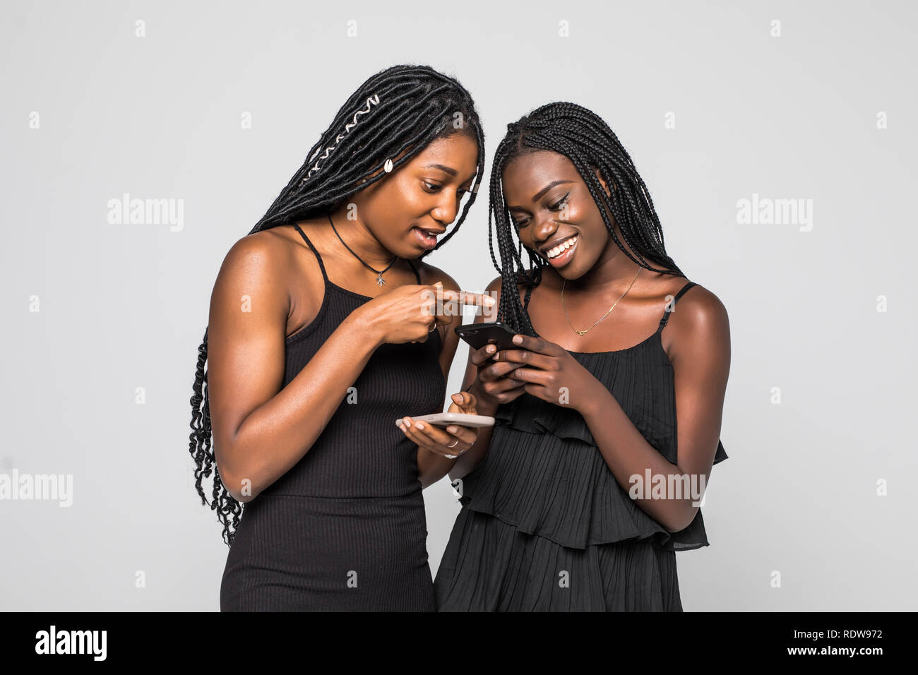 Two african women expressing excitement or surprise while both using ...