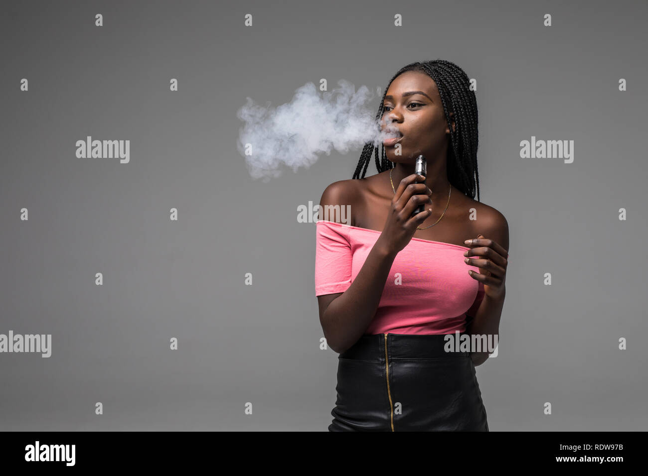 Young beauty african woman smoke vape, ecigarette, on gray background
