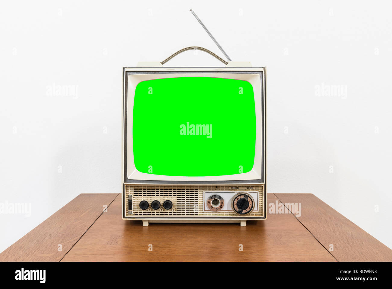 Grungy vintage portable television on table with chroma green screen. Stock Photo