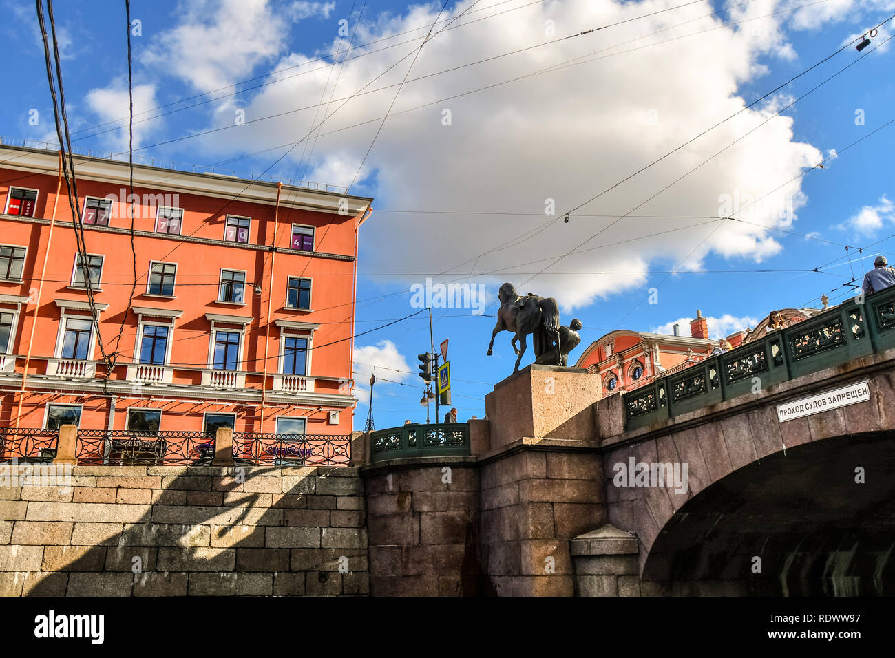 View from a canal of electrical and telephone wires crossing erratically above Anichkov Bridge and Horse Tamer sculpture in Saint Petersburg, Russia Stock Photo