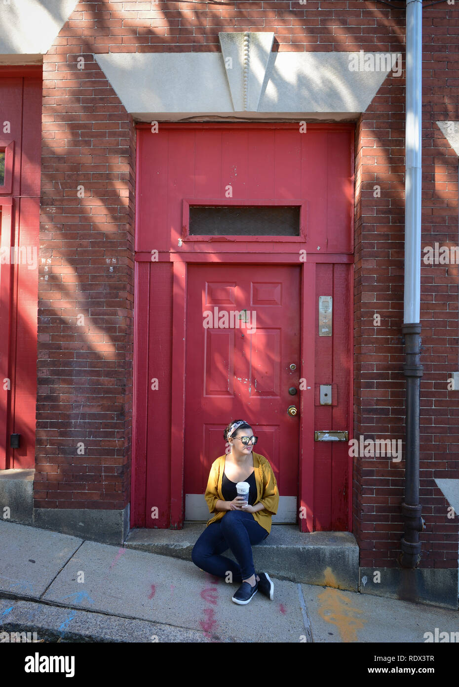 Young Woman On The Street Drinking Coffee And Siting On The