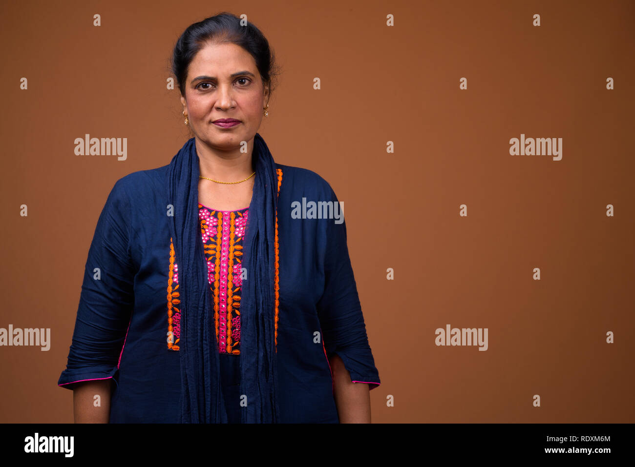 Mature beautiful Indian woman against brown background Stock Photo