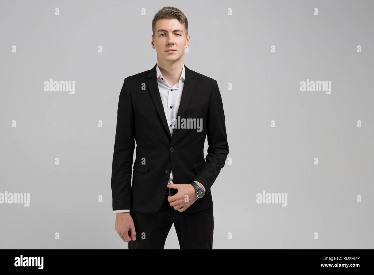 Portrait of young man in black suit isolated on white background Stock ...