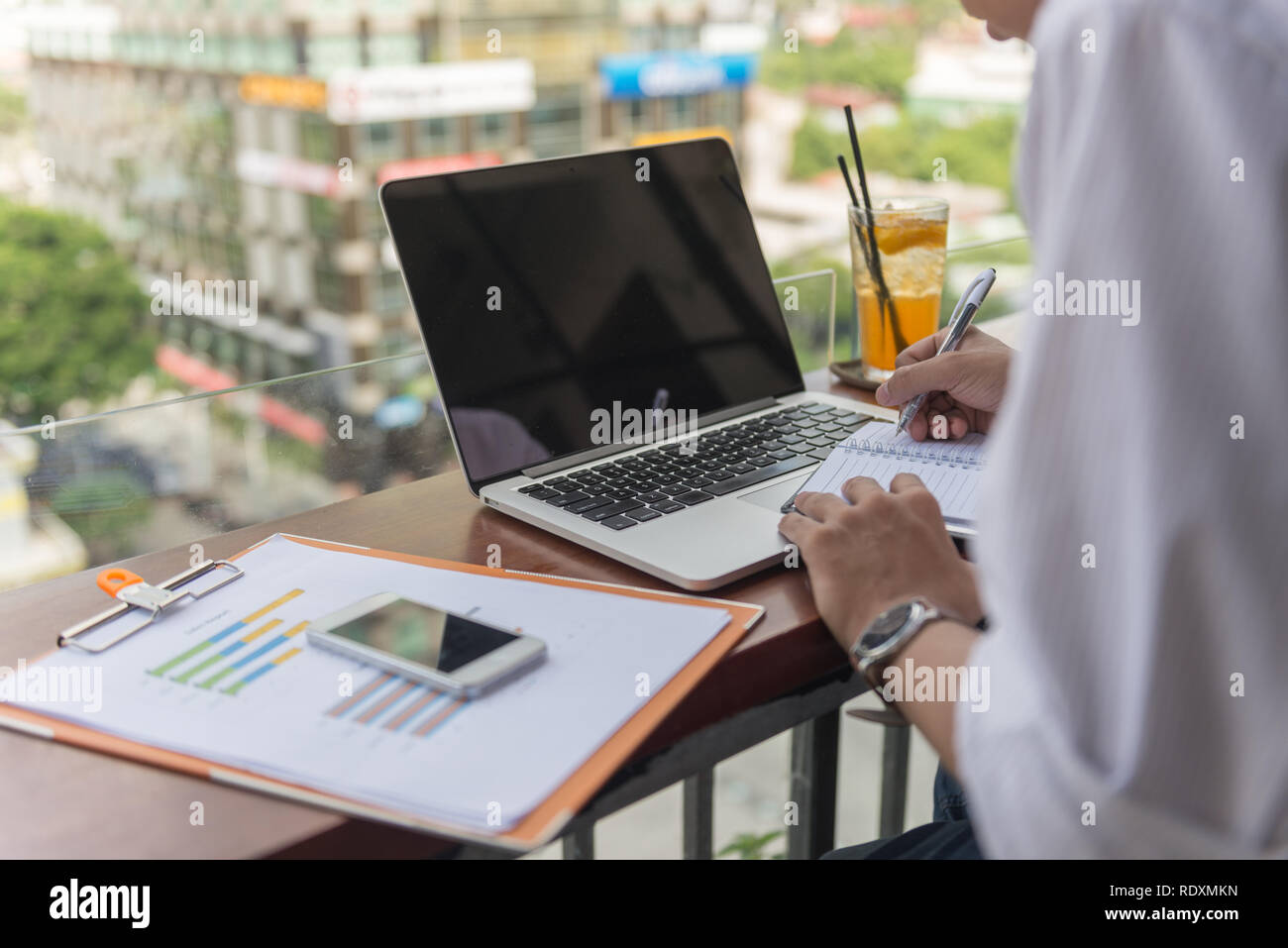 Asian freelancer writing notes outdoor Stock Photo