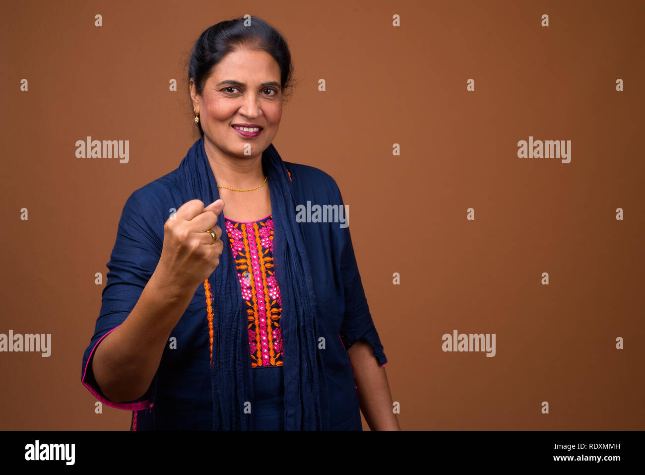 Mature beautiful Indian woman smiling with arm raised Stock Photo