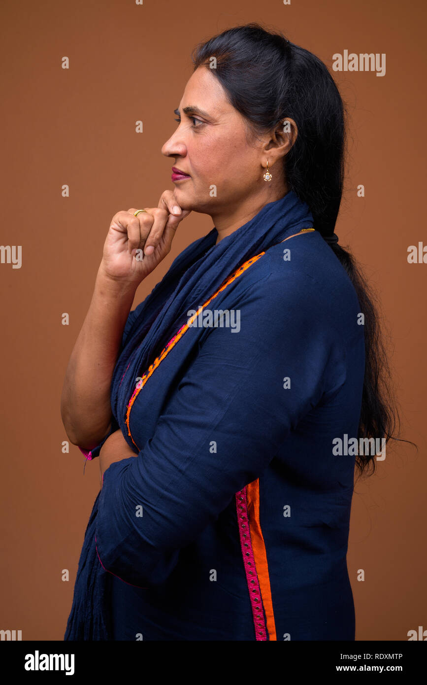 Profile view of mature beautiful Indian woman thinking Stock Photo - Alamy