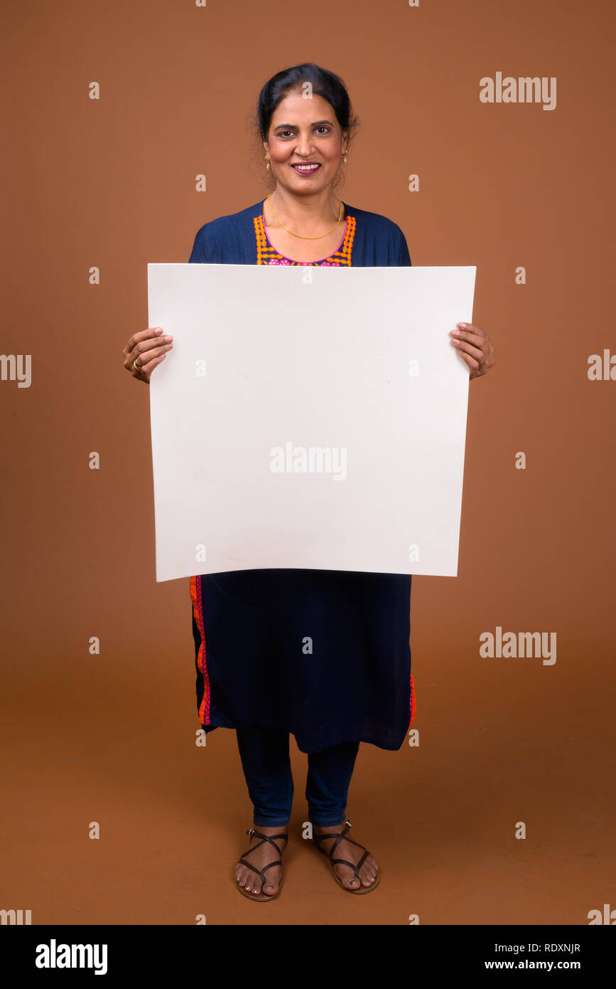 Happy Indian woman holding empty white board with copyspace Stock Photo