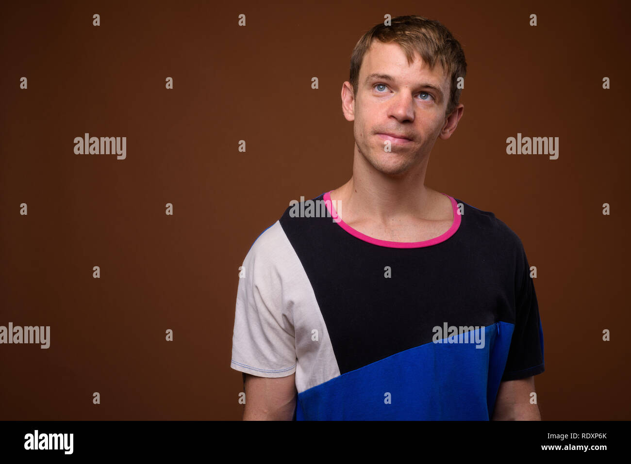 Man wearing blue shirt against brown background Stock Photo