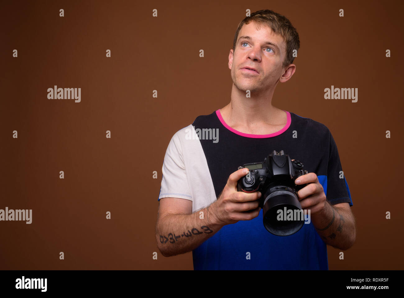 Portrait of photographer man using DSLR camera in studio Stock Photo