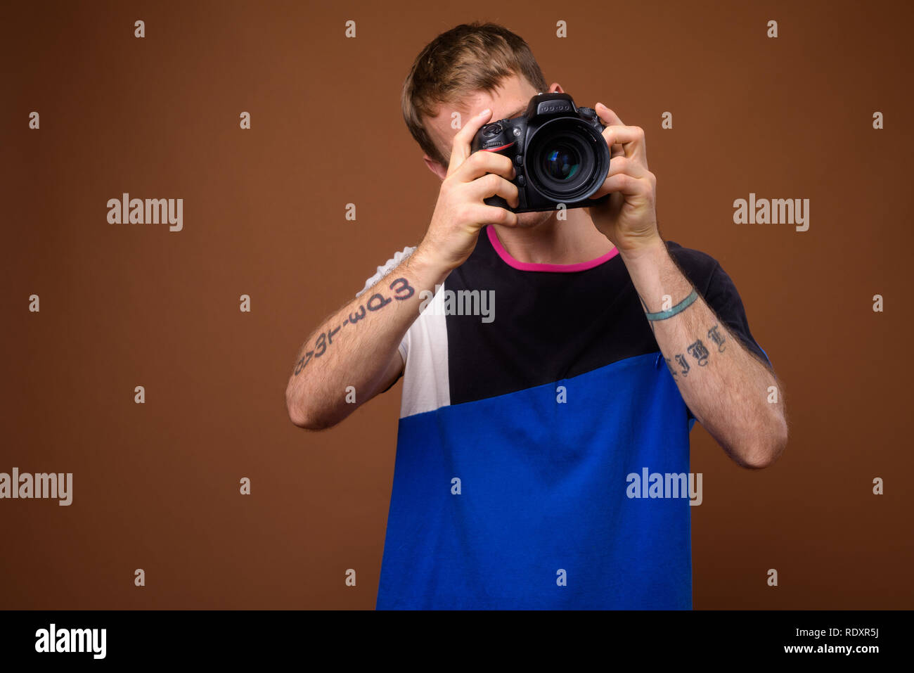 Portrait of photographer man using DSLR camera in studio Stock Photo