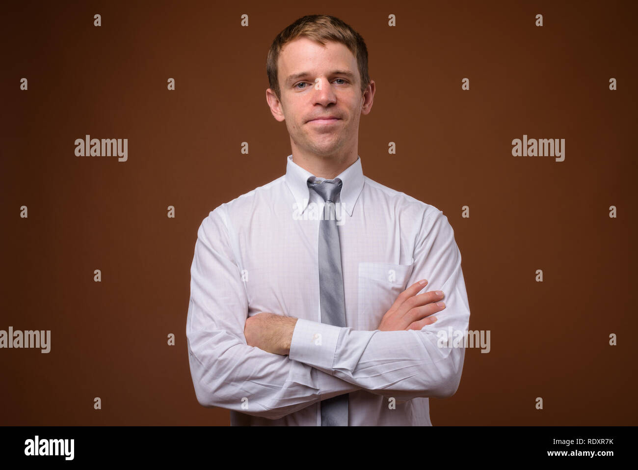 Businessman wearing white shirt against brown background Stock Photo