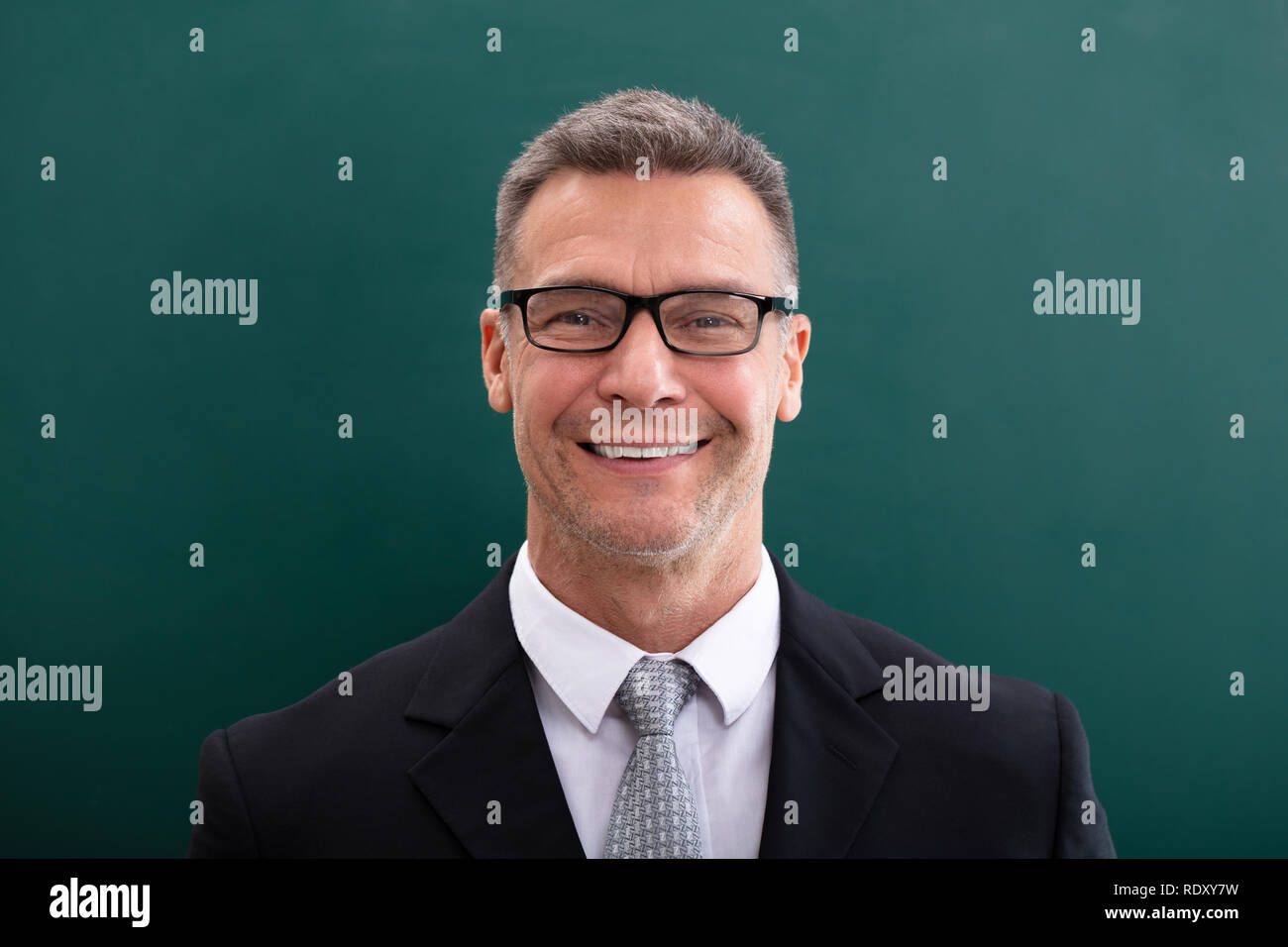 Happy Businessman In Spectacles Against Green Background Stock Photo