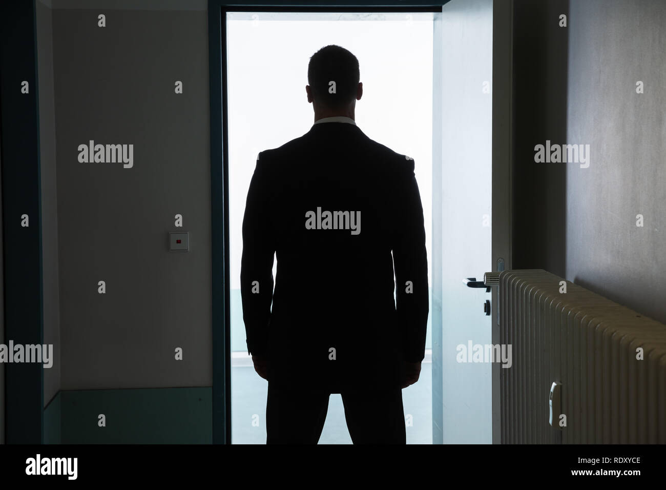 Rear View Of A Businessman Standing In Front Of Open Door Stock Photo