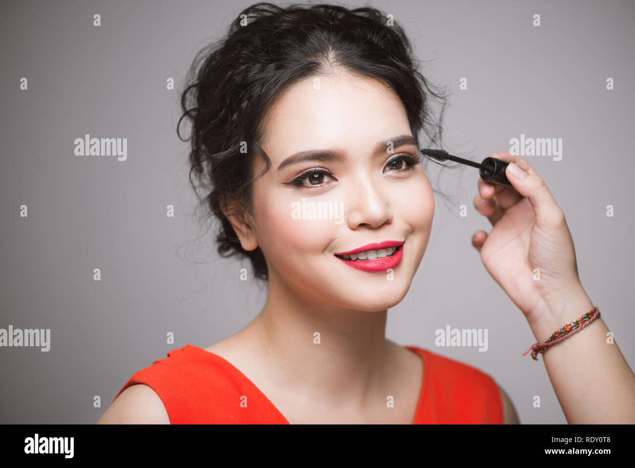 An asian woman applying mascara on her eyelashes Stock Photo Alamy
