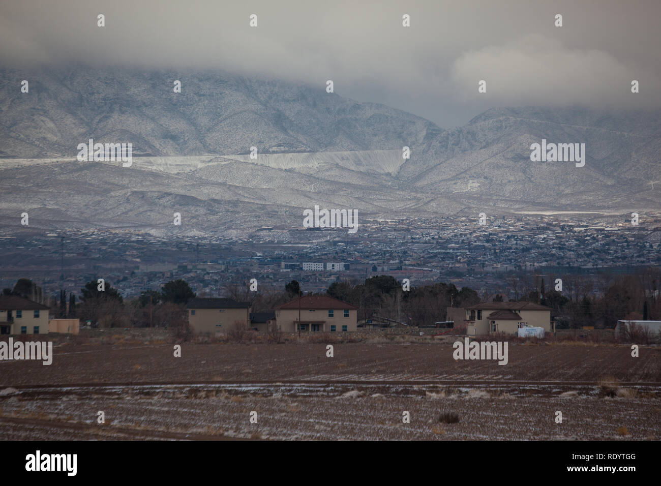 The snow covered Franklin Mountains and Transmountain Road rise from El