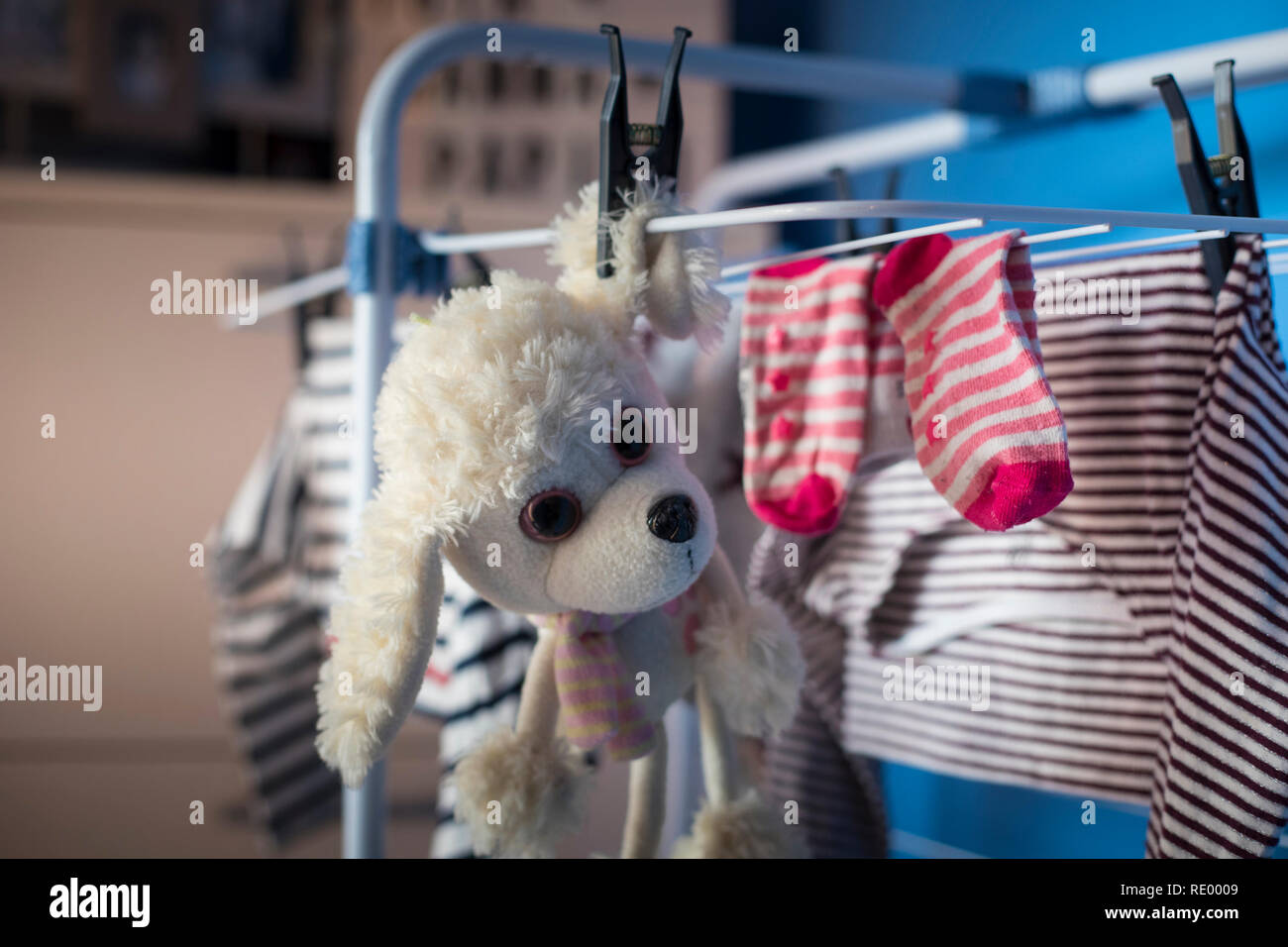 white dog plush toy hanging dry with laundry clothes after being washed