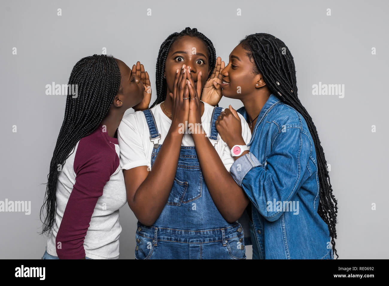 Three african girl friends sharing gossip isolated on white background Stock Photo