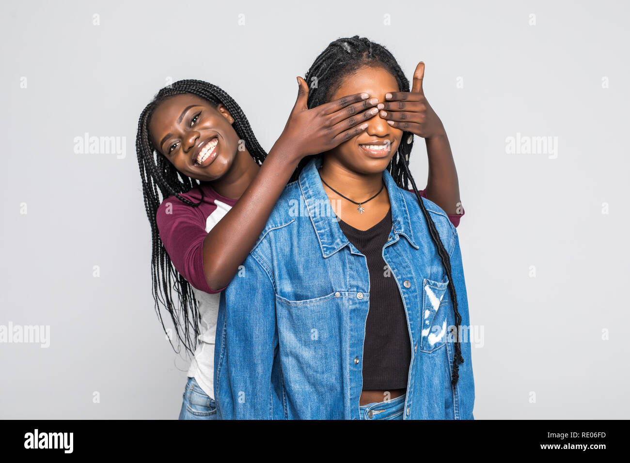 Portrait of two young african women make surprise and cover eyes on ...