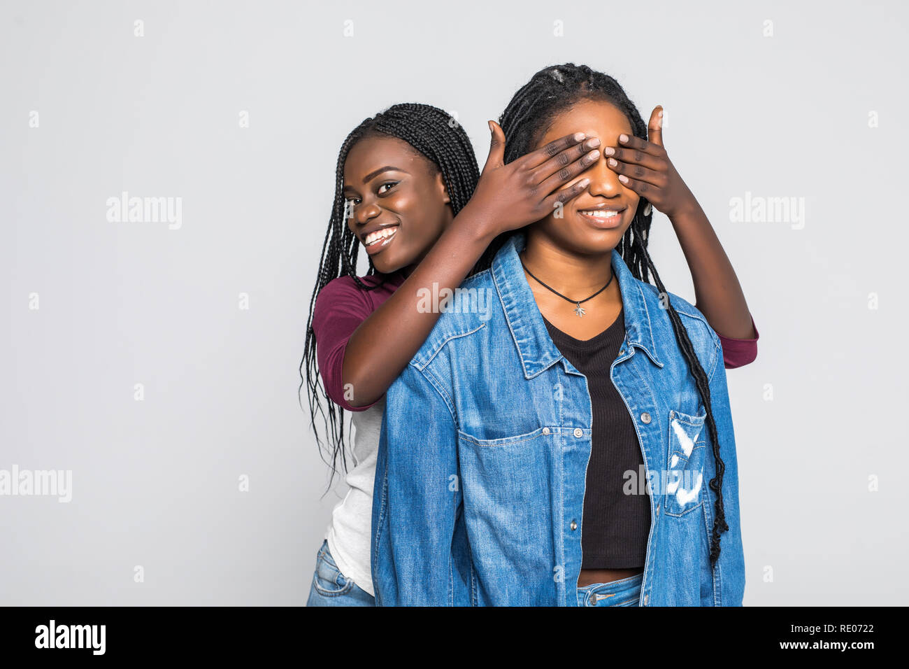 Portrait of two young african women make surprise and cover eyes on ...
