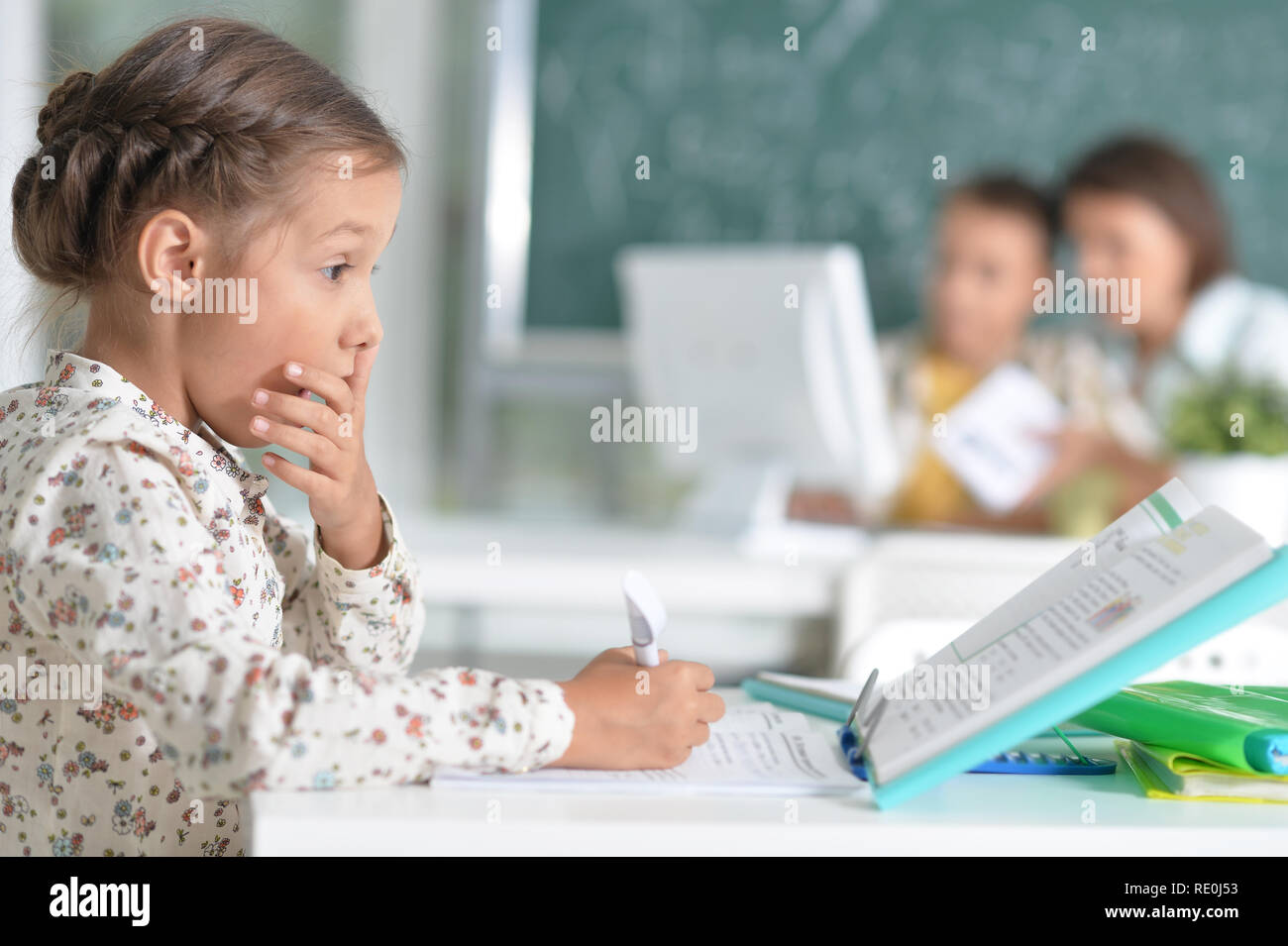 Portrait of cute little girl sitting in classroom Stock Photo - Alamy