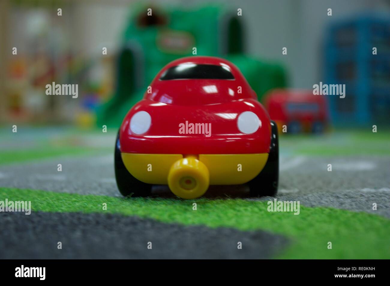 Bright red toy car on play mat Stock Photo