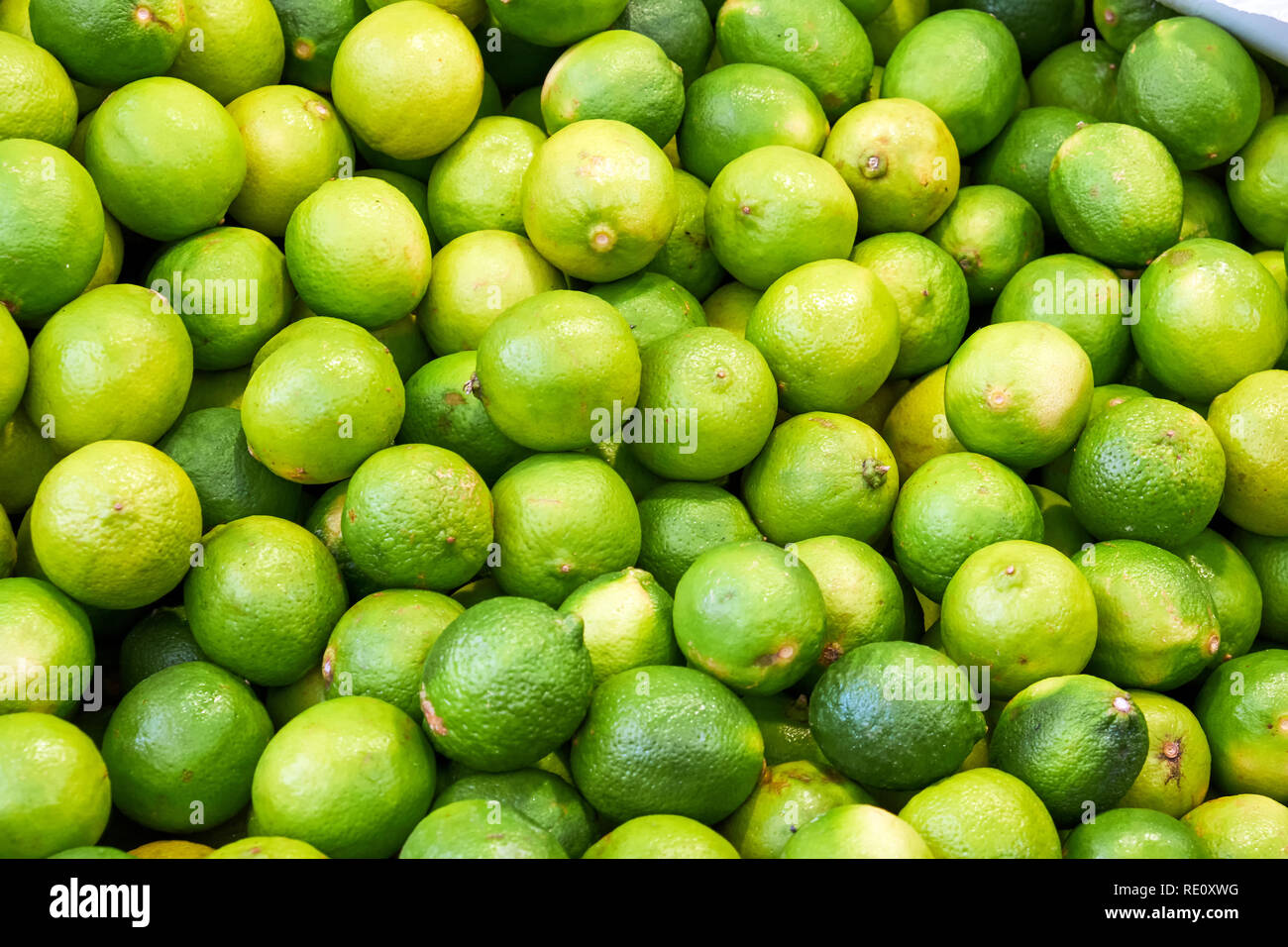 Lemons and limes with peeler sitting in bowl of a bar for